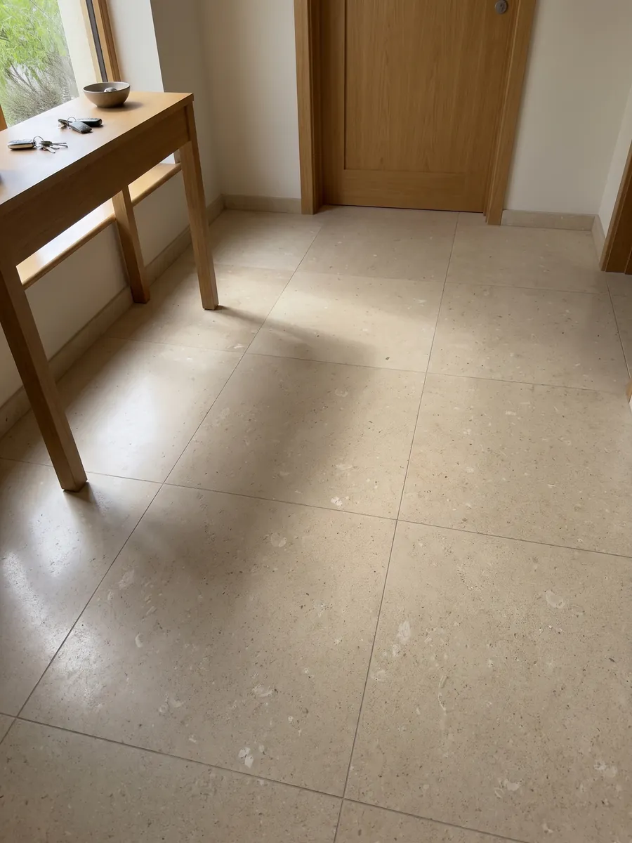 Piso de recibidor en placas grandes de Mármol Pietra di Vicenza Blanca con luz natural: beige arena de grano visible, con pequeños fragmentos claros