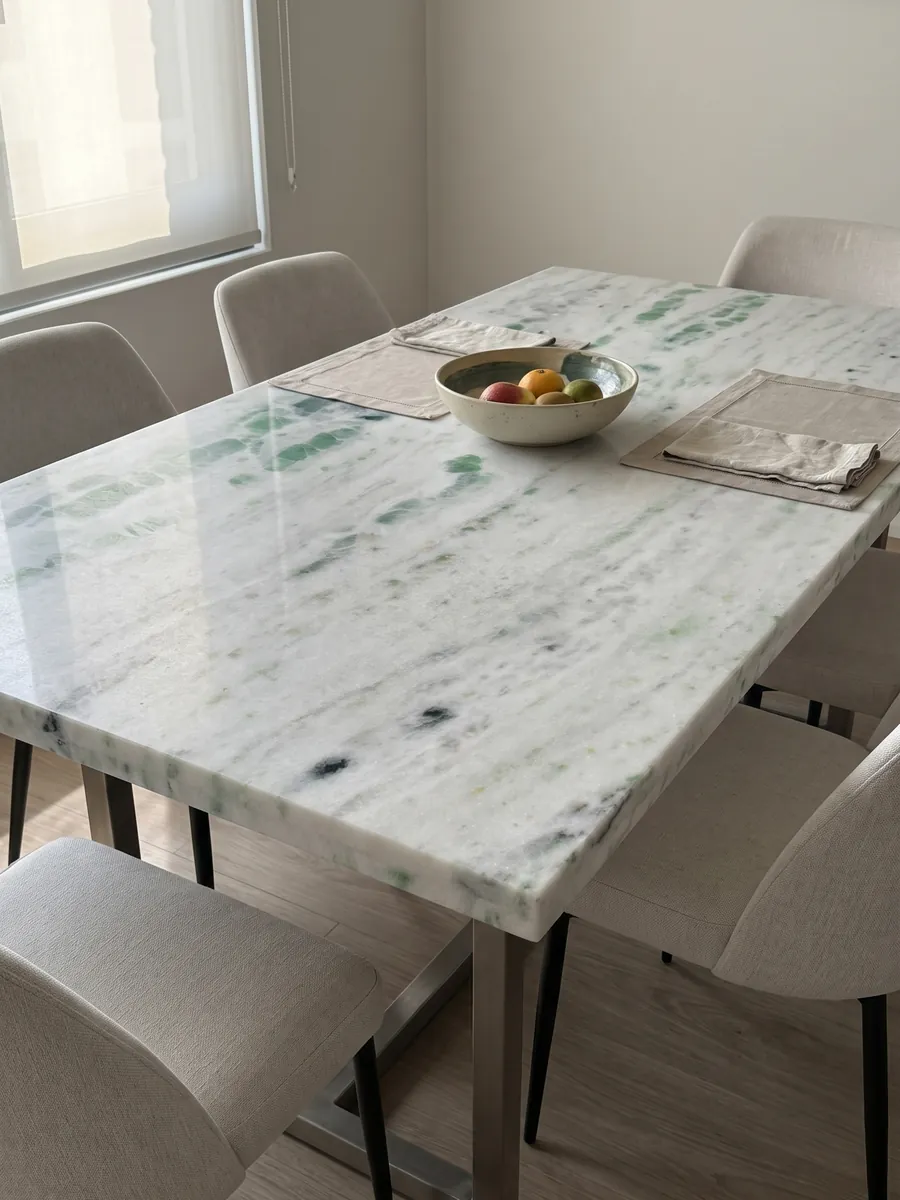 Mesa de comedor con cubierta de Mármol Pinta Verde sobre base de acero: blanco con franjas horizontales salpicadas de manchas verde esmeralda