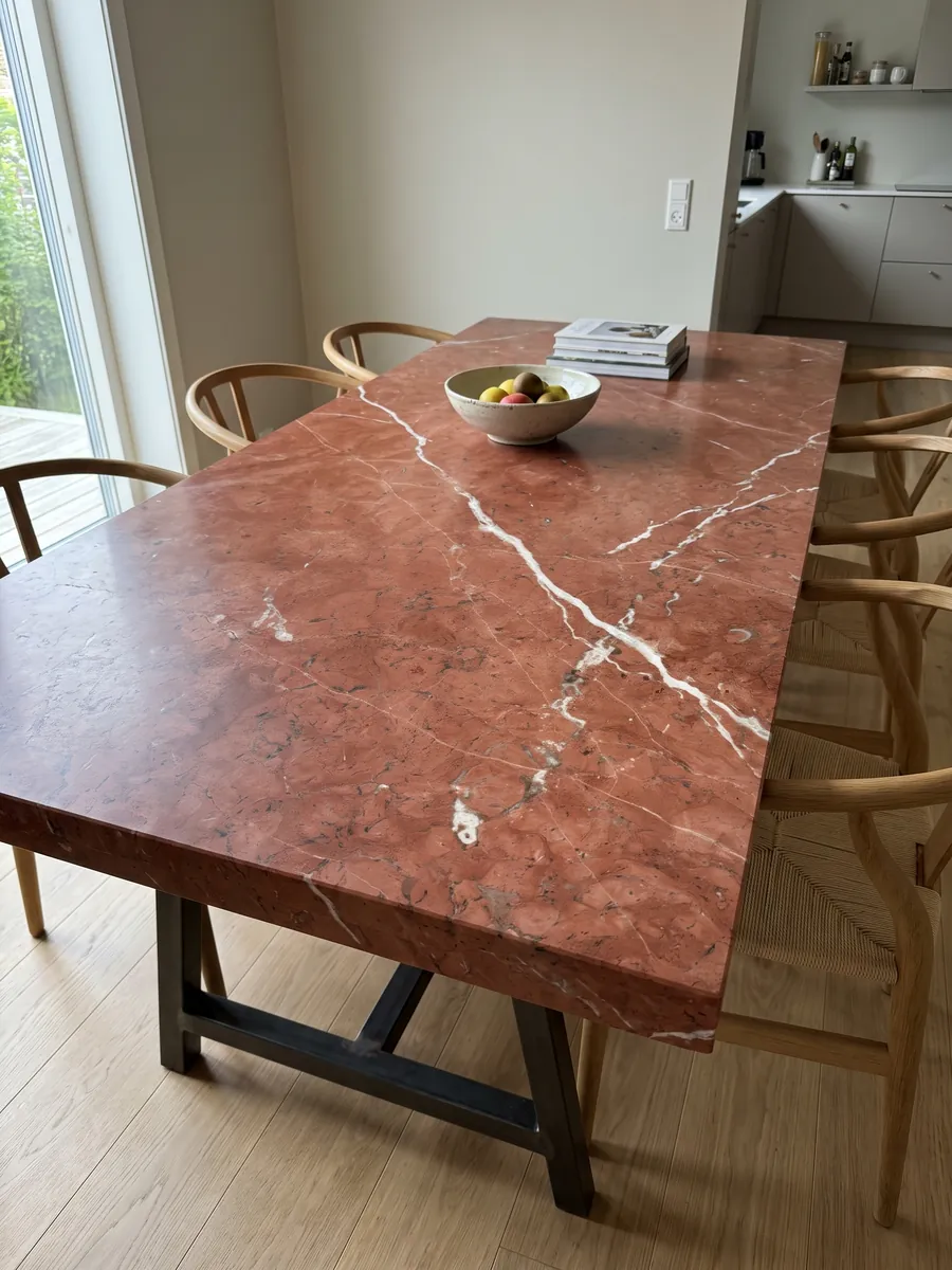 Mesa de comedor con cubierta de Mármol Rojo Alicante sobre base de acero: rojo terracota parejo cruzado por pocas vetas blancas en diagonal