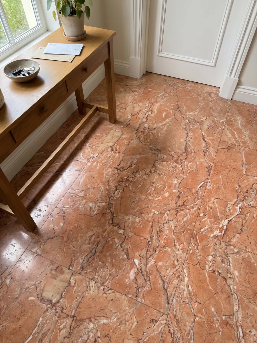 Piso de recibidor en placas grandes de Mármol Rosa Sabrina con luz natural: naranja salmón con una red densa de vetas finas blancas y rojizas