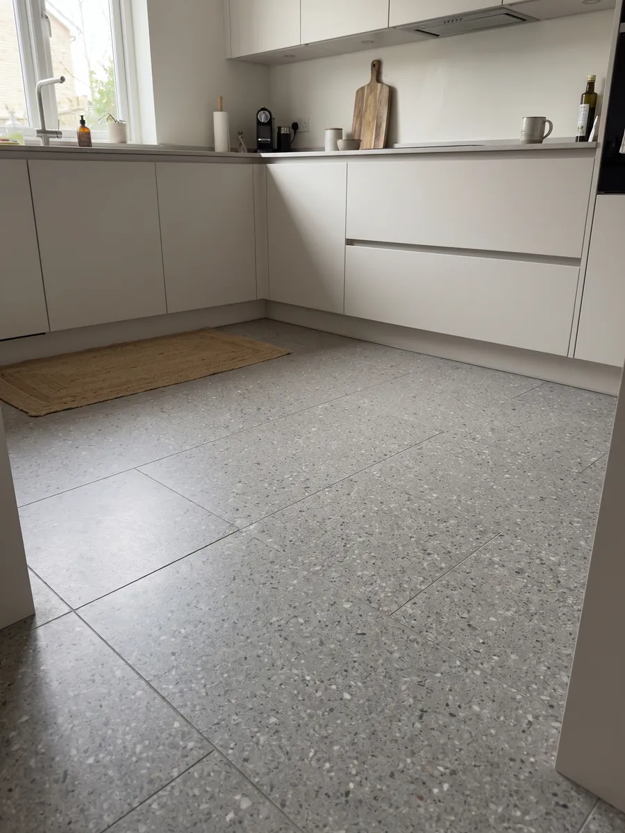 Piso de cocina en placas grandes de Mármol Sintético Fior di Pesco Grey con Cemento: gris medio con pequeños fragmentos blancos y oscuros, estilo terrazo fino