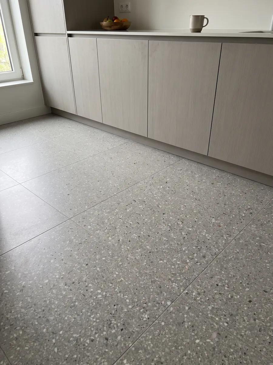 Piso de cocina en placas grandes de Mármol Sintético Fior di Pesco Grey con Resina: gris claro salpicado de muchos fragmentos blancos pequeños, estilo terrazo