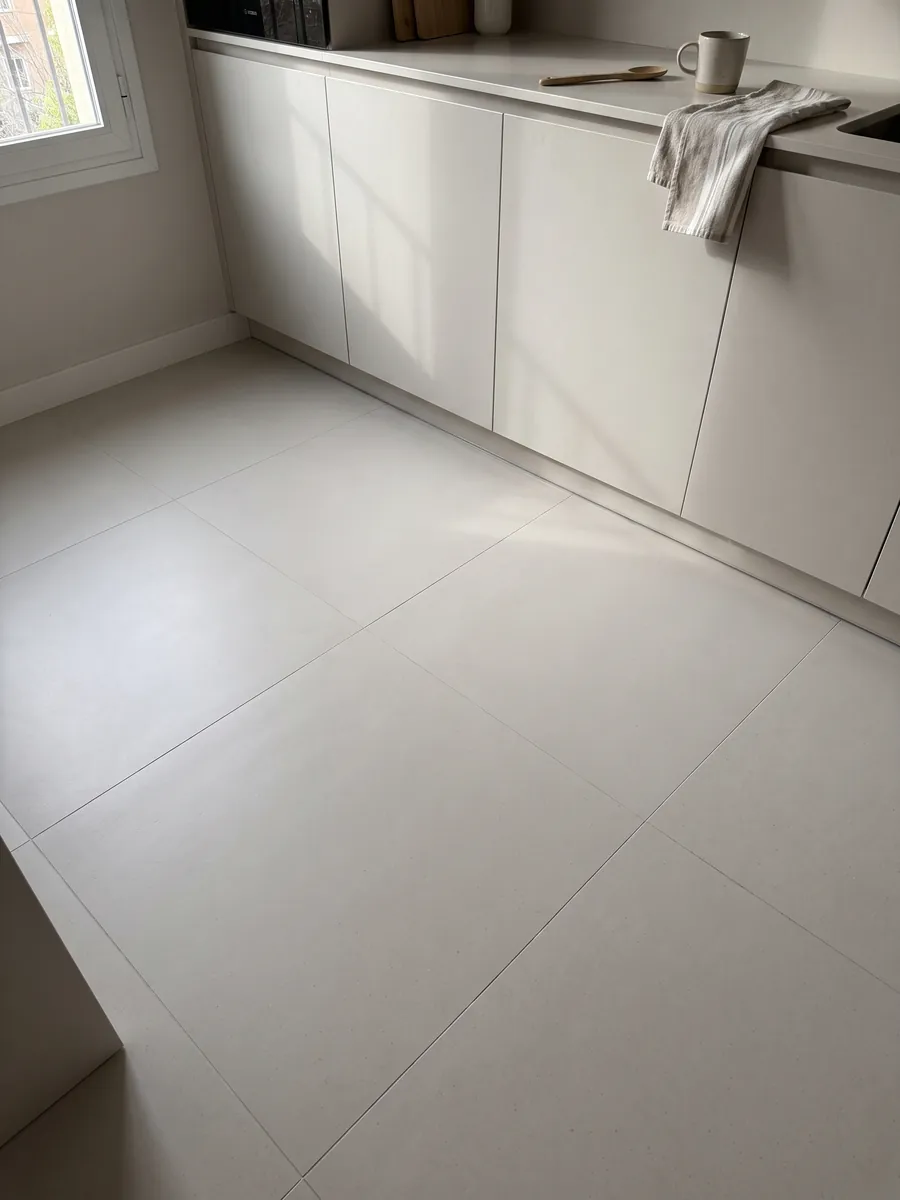 Piso de cocina en placas grandes de Mármol Sintético Veselje con Resina: color liso gris perla cálido; la imagen no muestra textura, solo un degradado de luz