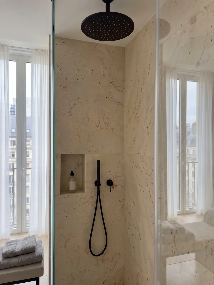 Ducha revestida con placas enteras de Mármol Trani Filetto Rojo con nicho empotrado: fondo crema con finos filamentos rojizos sinuosos y pequeños puntos oscuros aislados