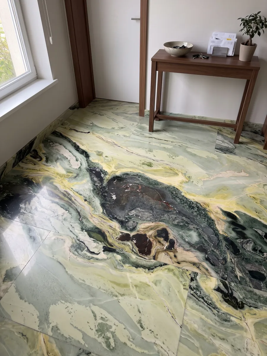 Piso de recibidor en placas grandes de mármol verde Dream Green con luz natural: ondas verde oscuro y amarillo lima con una zona central muy oscura