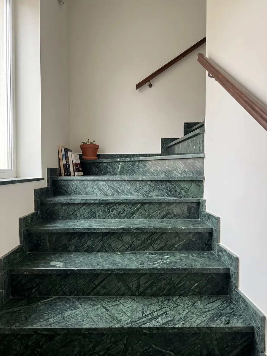 Escalera interior con peldaños de Mármol Verde Guatemala con pasamanos: verde bosque con una malla de vetas más claras que cruzan en diagonal