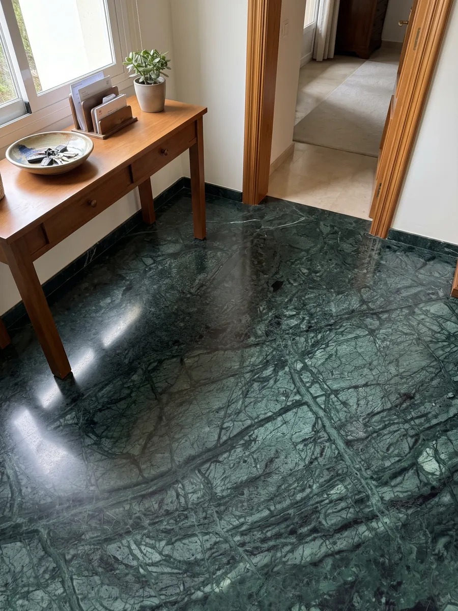 Piso de recibidor en placas grandes de Mármol Verde Imperial con luz natural: verde petróleo profundo con vetas finas más claras que cruzan en diagonal