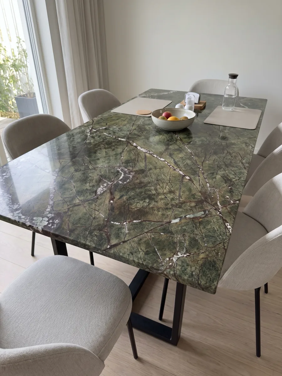 Mesa de comedor con cubierta de mármol verde Picasso Green sobre base de acero: verde oliva con red de vetas rojizas y vetas blancas en diagonal