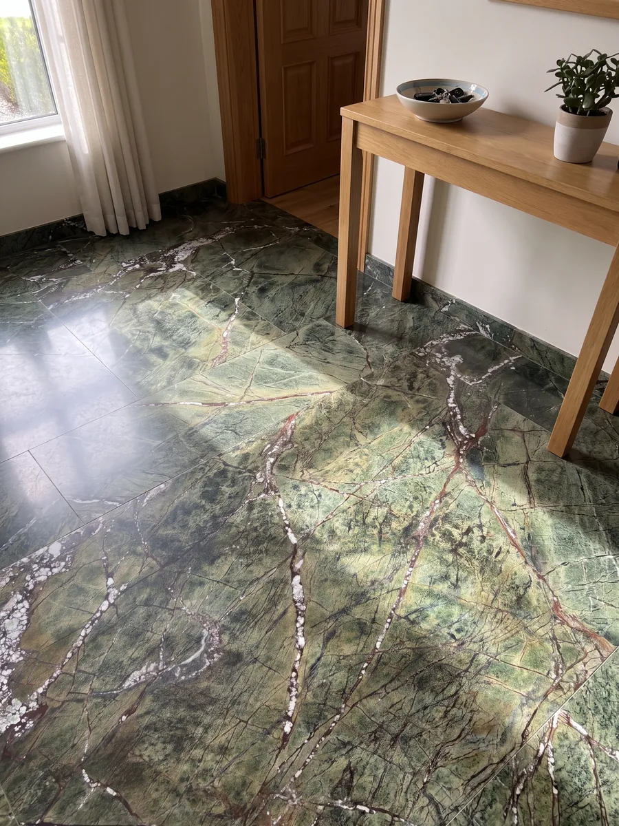 Piso de recibidor en placas grandes de mármol verde Picasso Green con luz natural: verde oliva con red de vetas rojizas y vetas blancas en diagonal