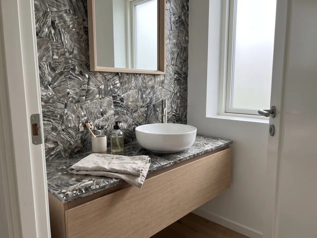 Cubierta de lavabo y pared de baño en Nácar Galushell Gris con lavamanos blanco y grifería cromada: piezas de concha gris plata con estrías onduladas de aspecto metálico