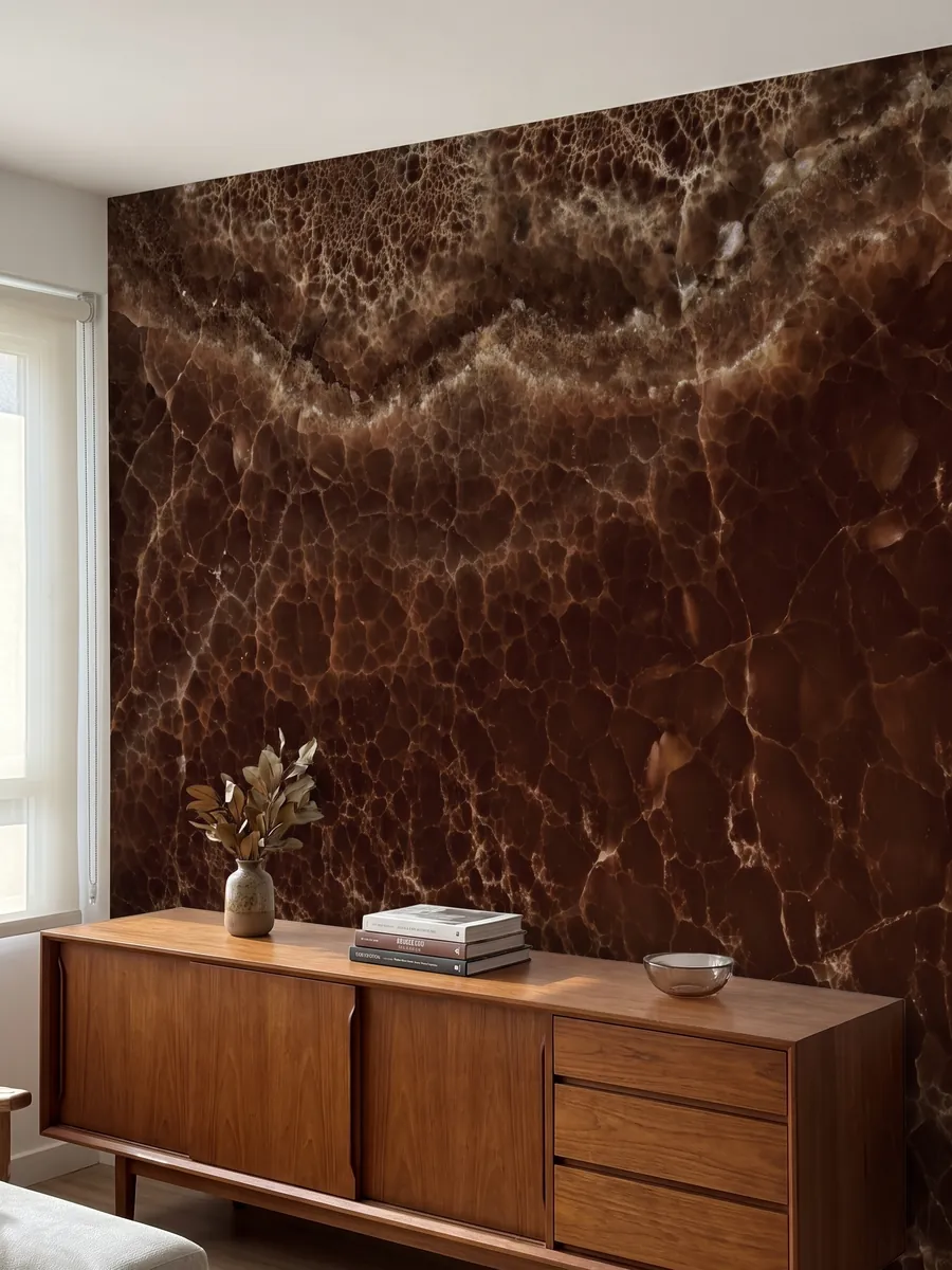 Pared de acento revestida con Ónix Marrón sobre un mueble bajo de madera: marrón profundo cubierto por una red fina de líneas claras y una banda burbujeante arriba