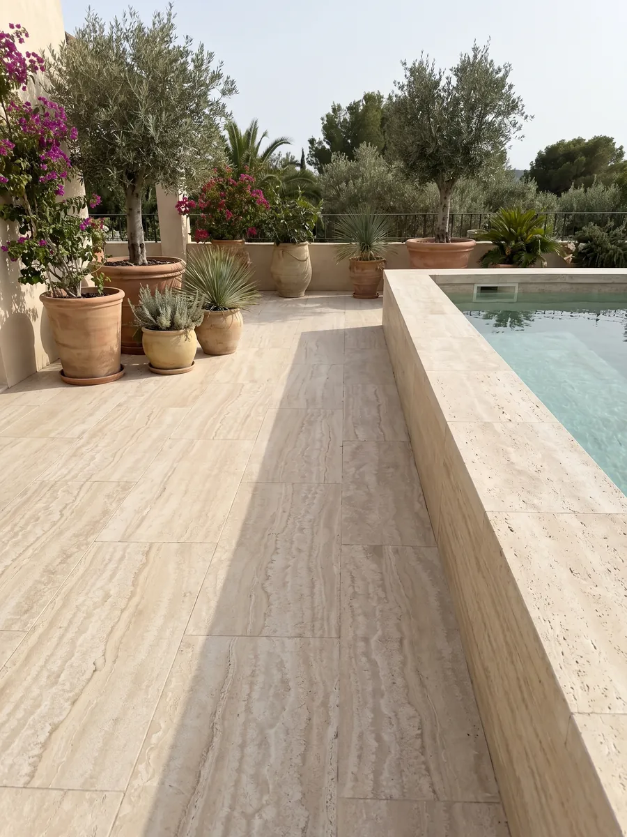 Piso de terraza y borde de piscina en travertino beige Paglierino con macetas: crema con bandas horizontales onduladas en tonos muy cercanos
