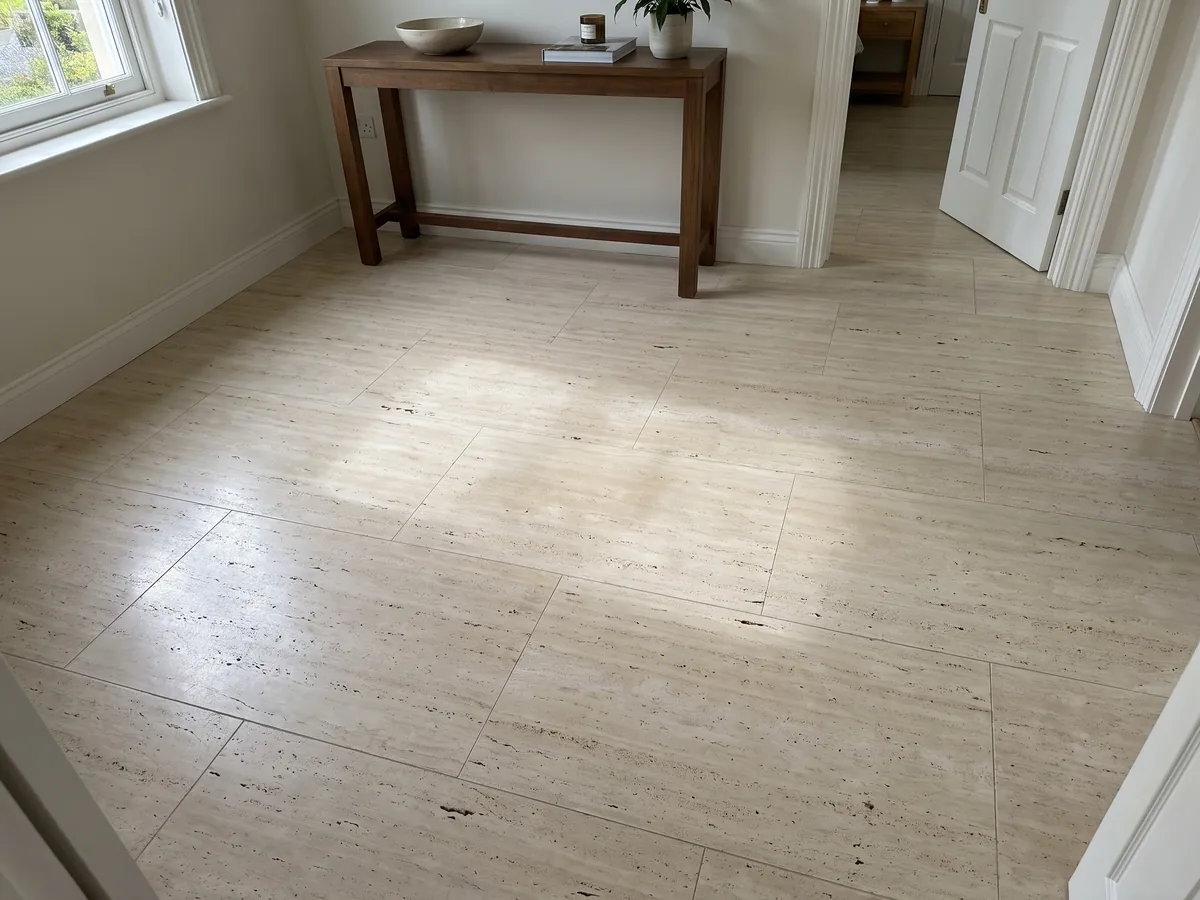 Piso de recibidor en placas grandes de travertino beige Romano Claro con luz natural: crema claro con líneas horizontales finas y pequeños poros alineados