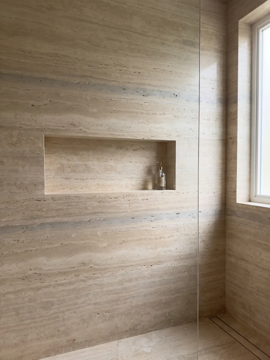 Ducha revestida con placas enteras de travertino beige Striato con nicho empotrado: beige con franjas horizontales finas y alguna banda gris más ancha