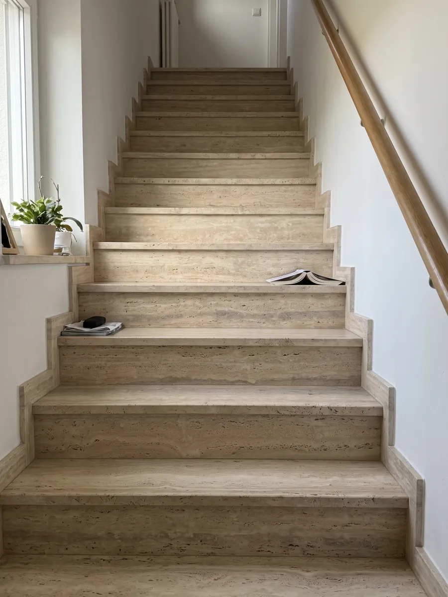 Escalera interior con peldaños de travertino beige Striato con pasamanos: beige con franjas horizontales finas y alguna banda gris más ancha