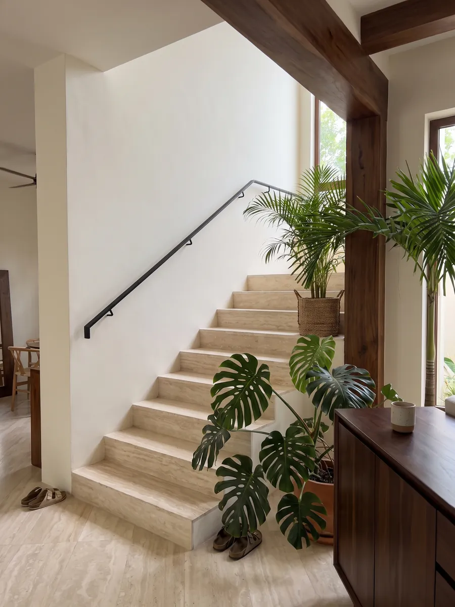 Escalera interior con peldaños de Travertino Blanco con pasamanos: crema marfil muy uniforme con ondas suaves apenas visibles