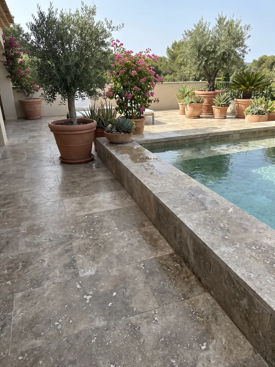 Piso de terraza y borde de piscina en travertino marrón Noce con macetas: marrón grisáceo con manchas claras irregulares y poros visibles