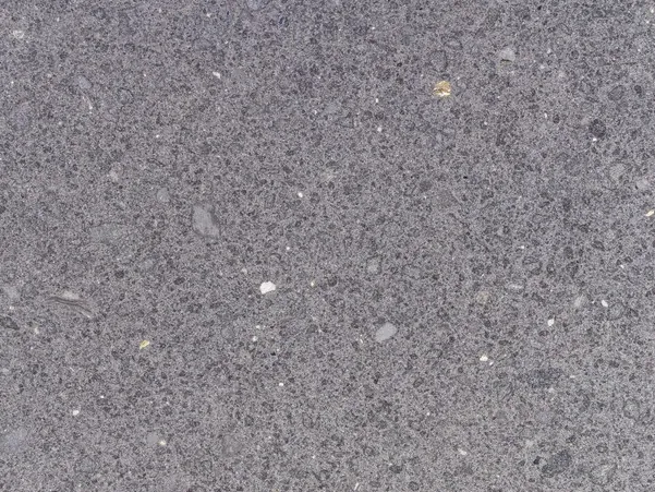 Detalle del Lavagrigia: poros pequeños y puntos blancos sobre el grano gris violáceo