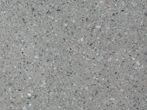 Detalle del Fior di Pesco Grey con cemento: fragmentos blancos y oscuros repartidos sobre el gris medio