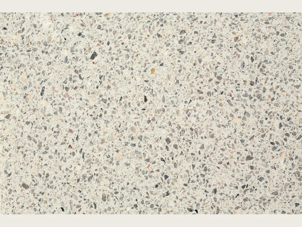 Placa de Mármol Sintético Fior di Pesco White con Resina: fondo marfil con fragmentos grises y oscuros estilo terrazo