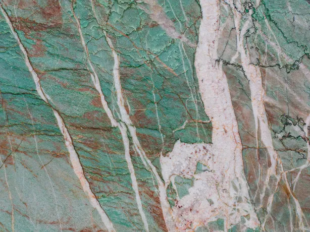 Detalle de la Cuarcita Amazzonite Cristallo: líneas finas rojo óxido y oscuras sobre el pulido brillante