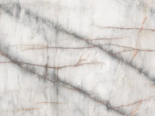 Detalle de la Cuarcita Cristallo Black: vetas gris oscuro difuminadas y líneas naranjas finas sobre el blanco