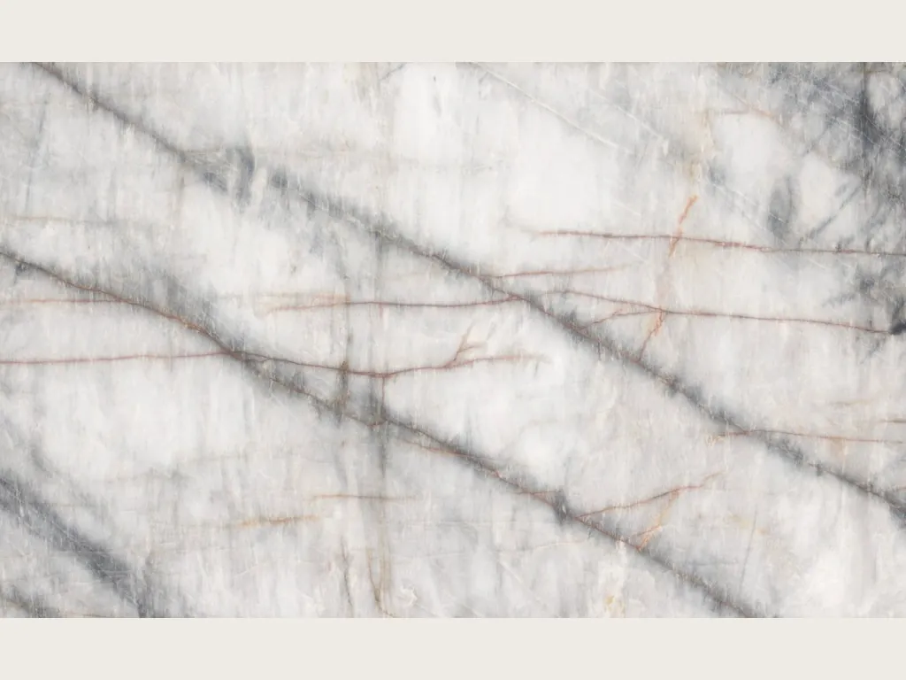 Placa de cuarcita blanca Cristallo Black: fondo blanco con vetas oscuras difuminadas en diagonal y líneas naranjas finas