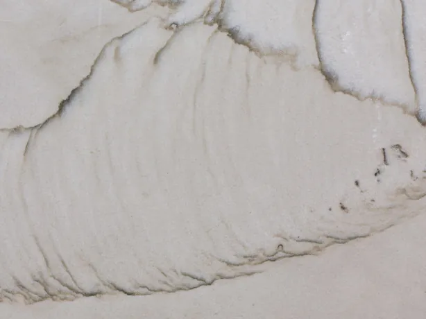 Detalle de la Cuarcita Dune: vetas finas gris oscuro y toques gris claro sobre el pulido
