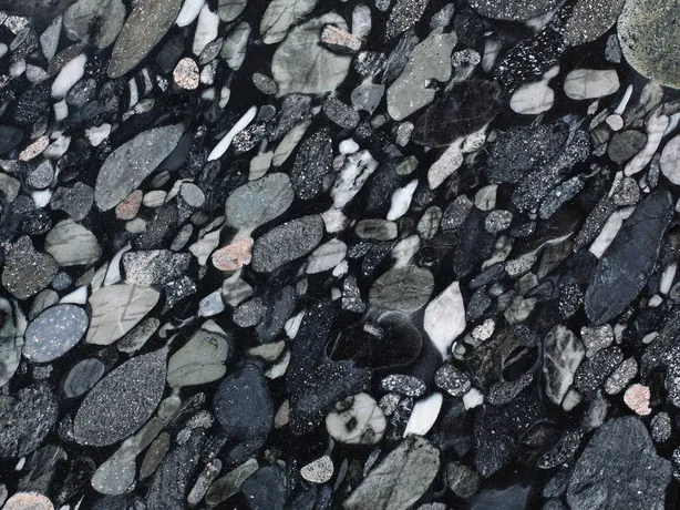 Detalle de la Marinace Black: cantos rodados apretados de muchos tamaños sobre el fondo negro