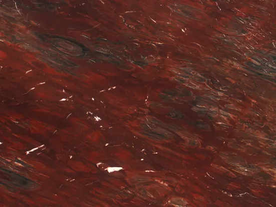 Detalle de la cuarcita roja Napoleon Bordeaux: trazos blancos y zonas oscuras sobre el vino, con brillo de pulido