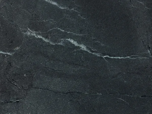 Detalle de la Cuarcita Negresco: vetas blancas finas sobre el brillo del pulido