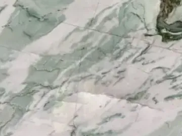 Detalle de la Cuarcita Tiffany Wow: vetas onduladas verde oscuro con trazos blancos y reflejos del pulido