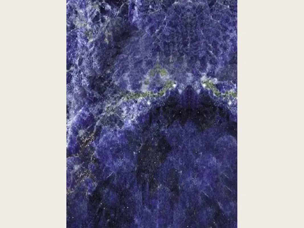 Placa de granito azul Jeriba Blue: azul violeta intenso con nubes blancas y una línea horizontal verde dorado