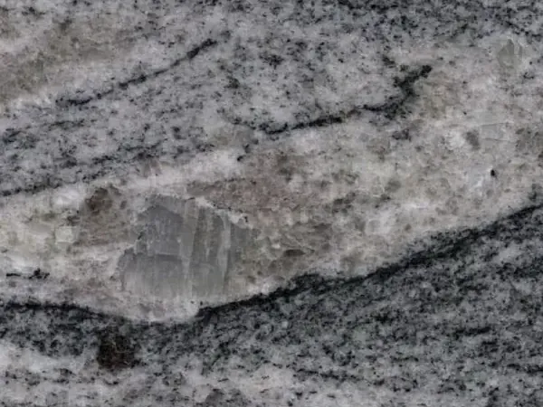 Placa de Granito Piracema White: bandas onduladas de gris y blanco en horizontal con un gran fragmento claro