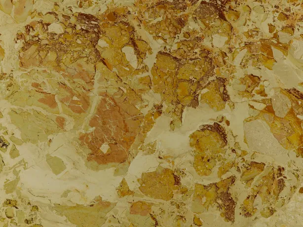 Detalle del Mármol Alma Fuoco: bordes oscuros de los fragmentos ocre y óxido sobre el crema verdoso