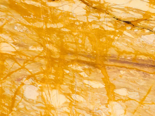 Detalle del Mármol Amarillo Siena: vetas amarillas finas y gruesas en todas direcciones sobre crema