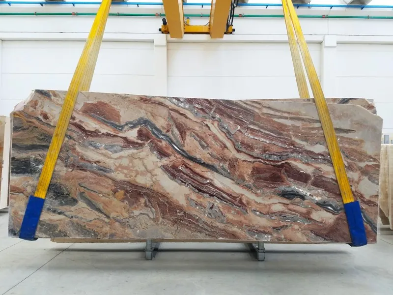 Placa de mármol rojo Arabescato Rosso: bandas onduladas horizontales de rojo ladrillo, crema y gris azulado (otra placa)