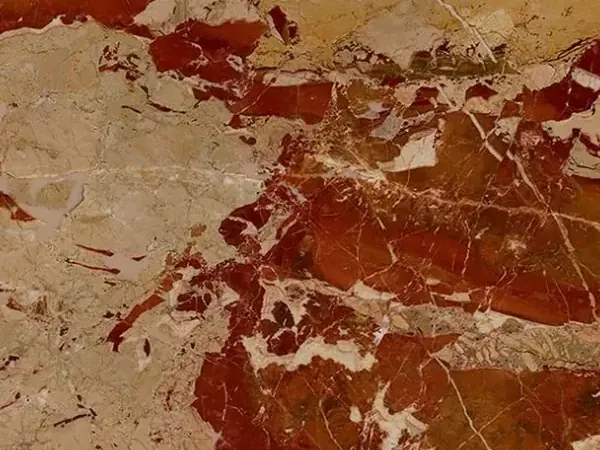 Placa de Mármol Arlecchino: manchas rojo óxido grandes sobre fondo beige rosado con una red de vetas blancas finas