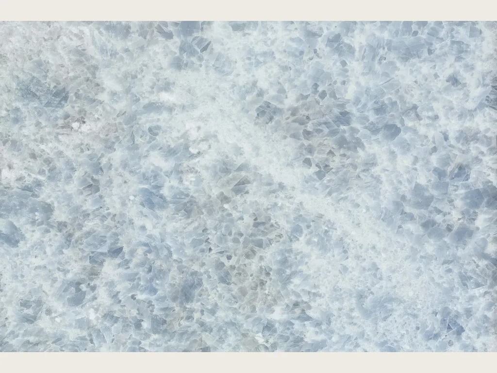 Placa de Mármol Azul Calcite: cristales azul grisáceo sobre blanco, con una franja blanca en diagonal