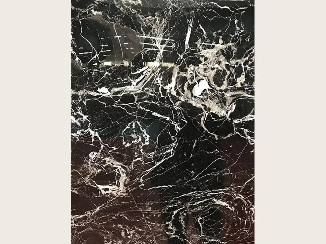 Placa de Mármol Black Rose: fondo negro con una trama densa de vetas blancas y una zona inferior marrón