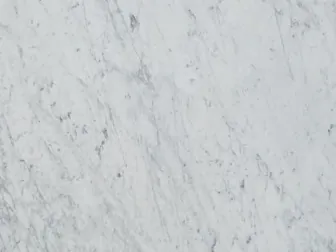 Detalle del Mármol Bianco Carrara C Extra: trazos grises finos y difusos sobre el fondo blanco