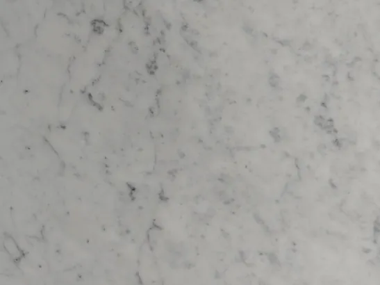 Detalle del mármol blanco Carrara: red de trazos grises difusos sobre el fondo blanco grisáceo
