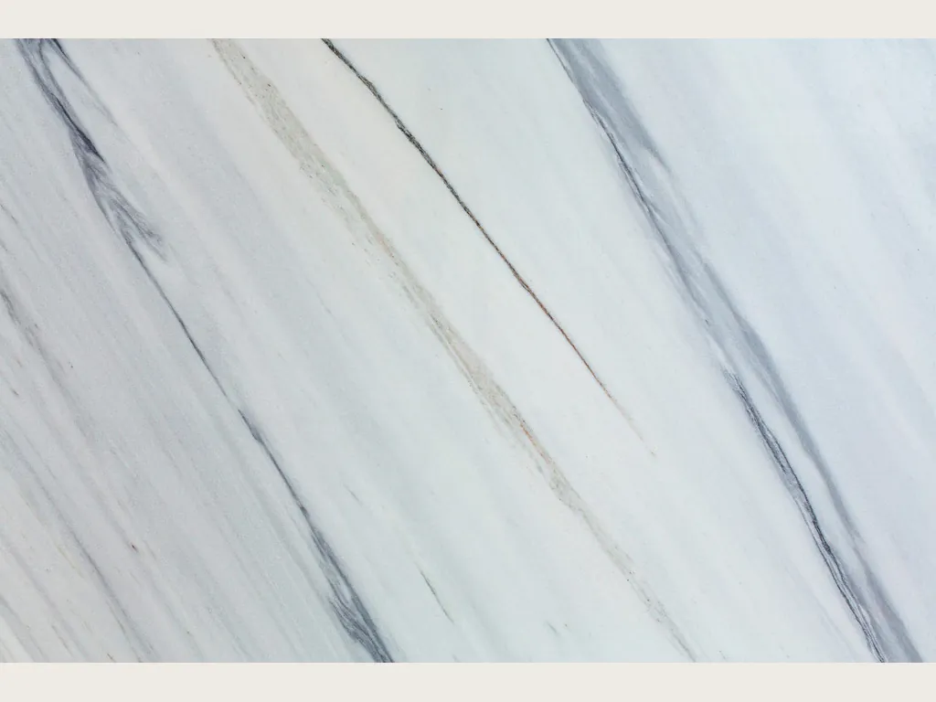 Placa de mármol blanco Bianco Covelano: vetas gris azulado rectas y paralelas en diagonal sobre blanco