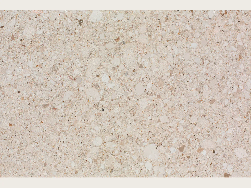 Placa de Mármol Blanco Romano: fondo beige rosado moteado con clastos claros y oscuros
