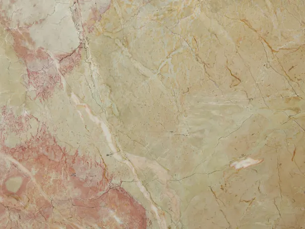 Detalle del Mármol Breccia D’Aragona: vetas claras finas y manchas rosa coral sobre el beige