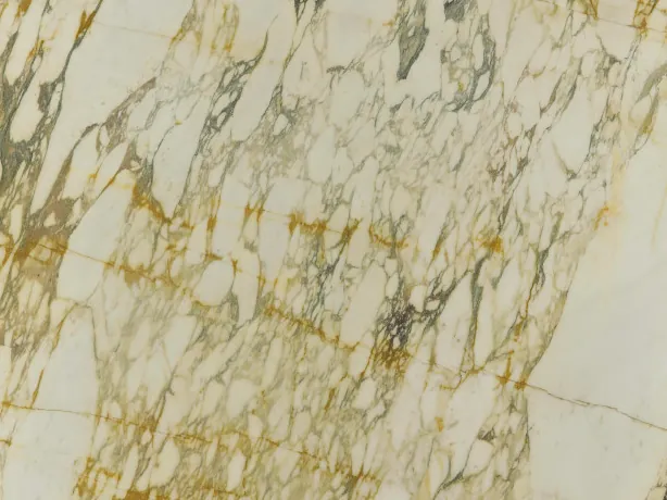 Detalle del Calacatta Monet Gold: vetas doradas y gris oscuro rodeando los fragmentos crema