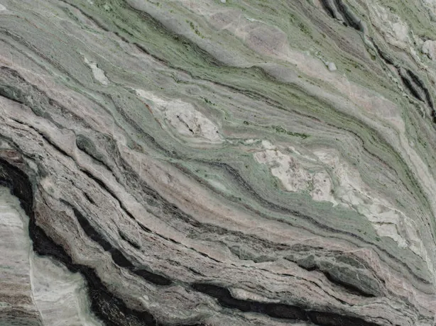 Detalle del Mármol Camellia Green: bandas densas y brillo de pulido sobre el verde grisáceo