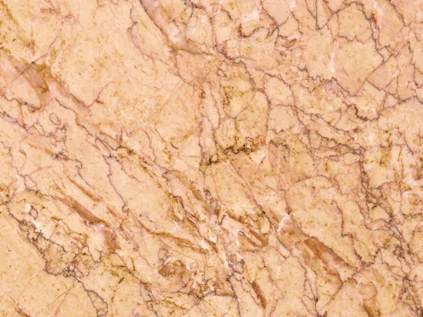 Detalle del Mármol Crema Valencia: vetas marrones finas cruzándose sobre el salmón