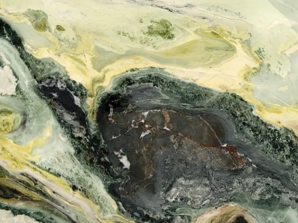 Detalle de la placa de Dream Green: brillo del pulido y una onda verde oscuro sobre el fondo lima pálido.