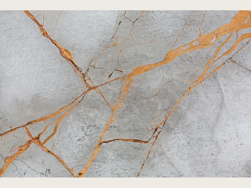Placa de mármol gris Golden Sky: vetas naranja dorado en diagonal sobre fondo gris claro nublado